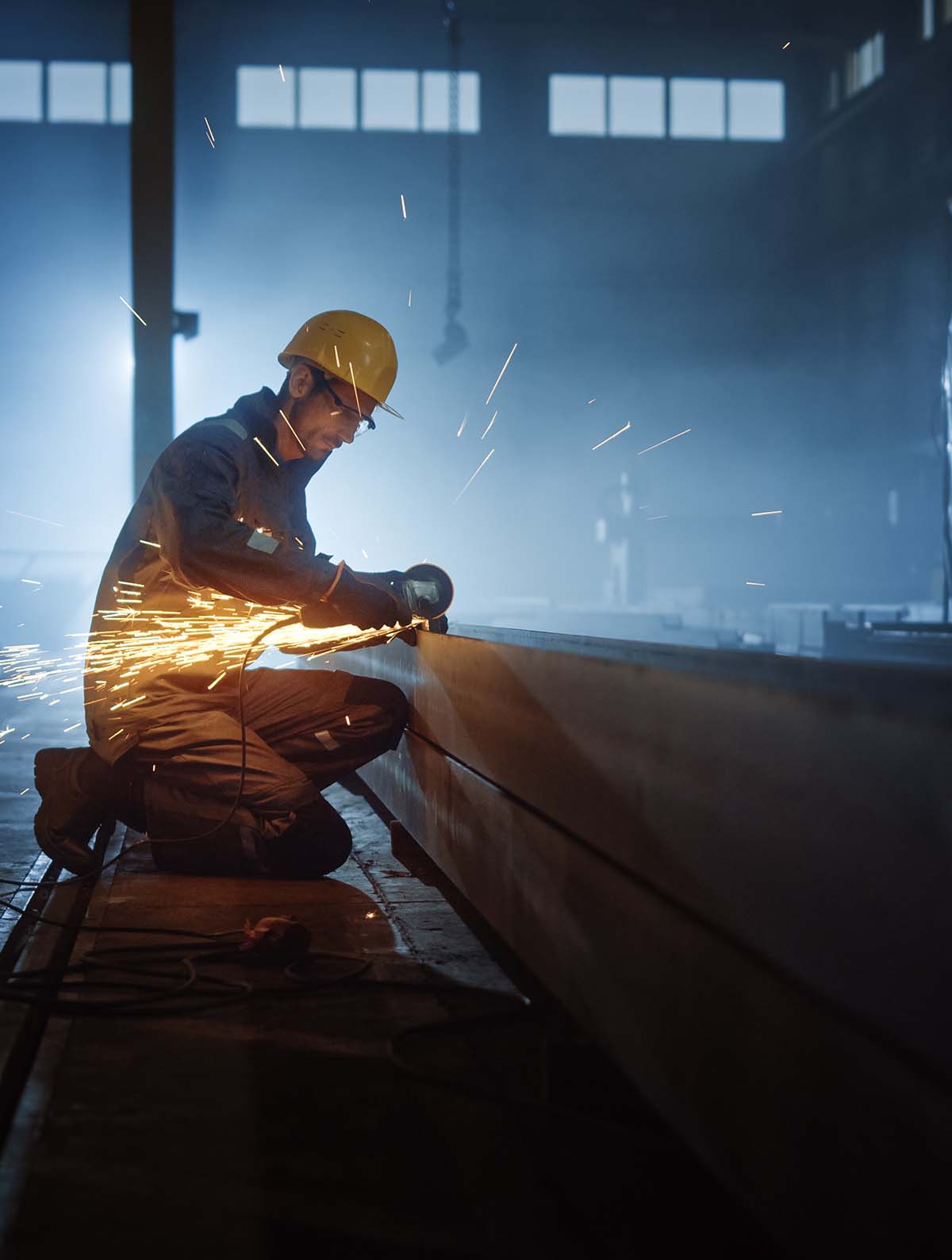 Steel worker grinding steel